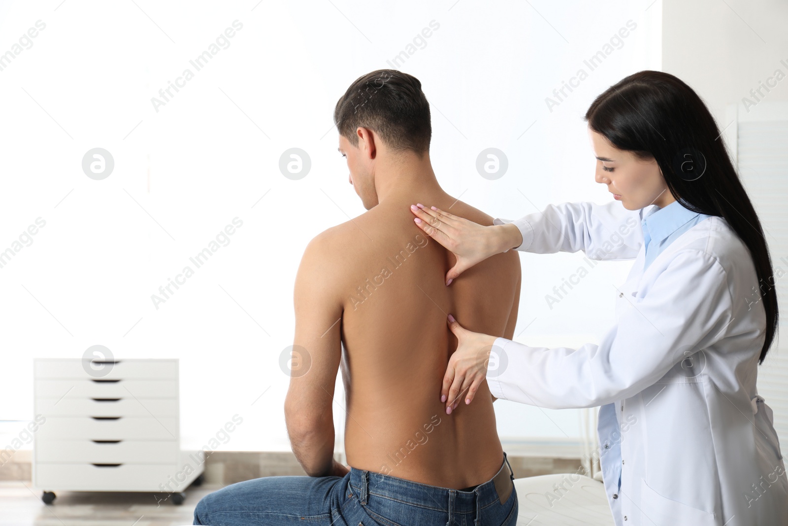 Photo of Professional orthopedist examining man in medical office