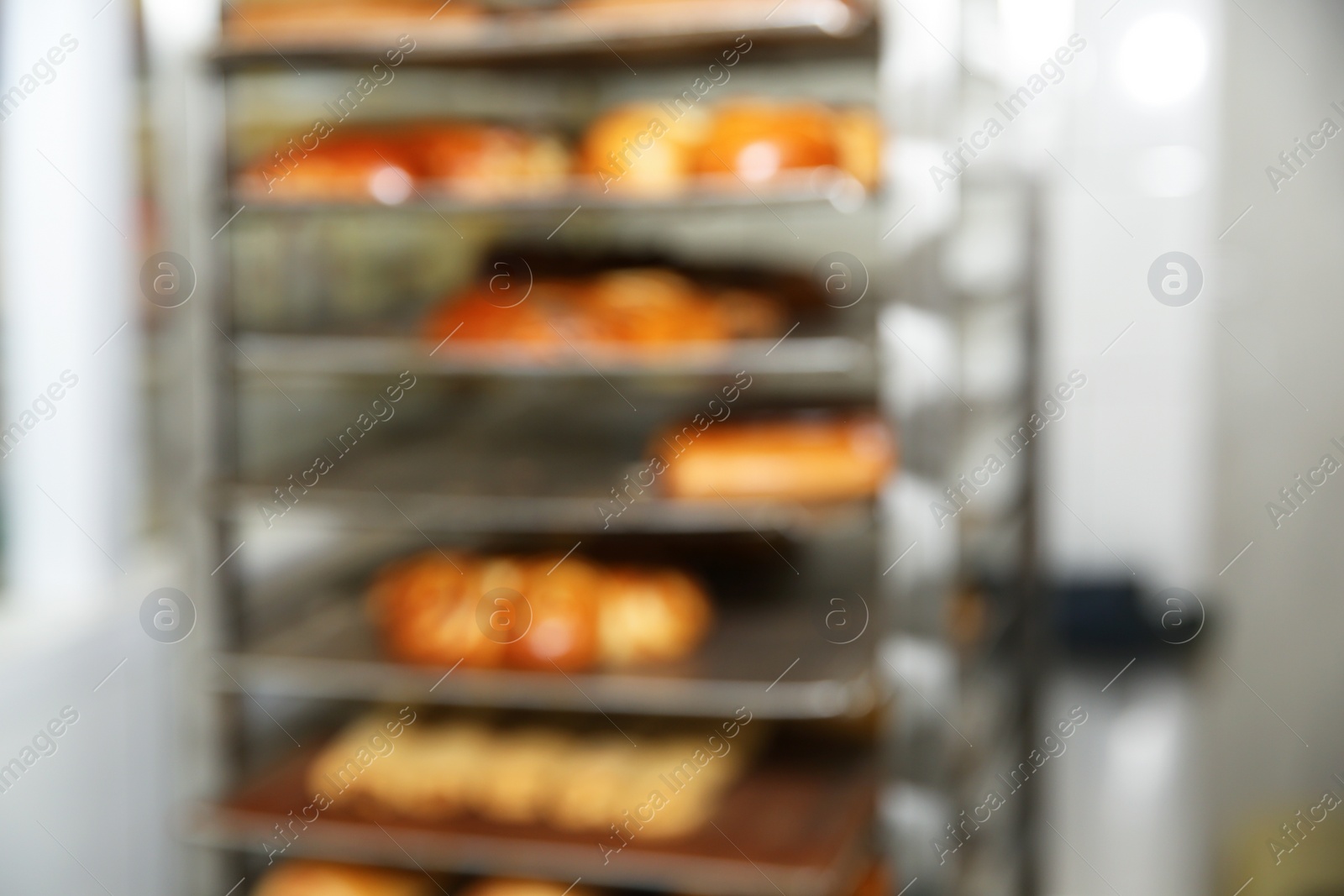 Photo of Blurred view of rack with pastries in bakery workshop