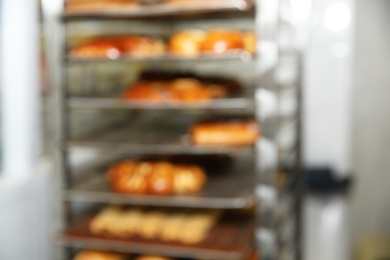 Blurred view of rack with pastries in bakery workshop