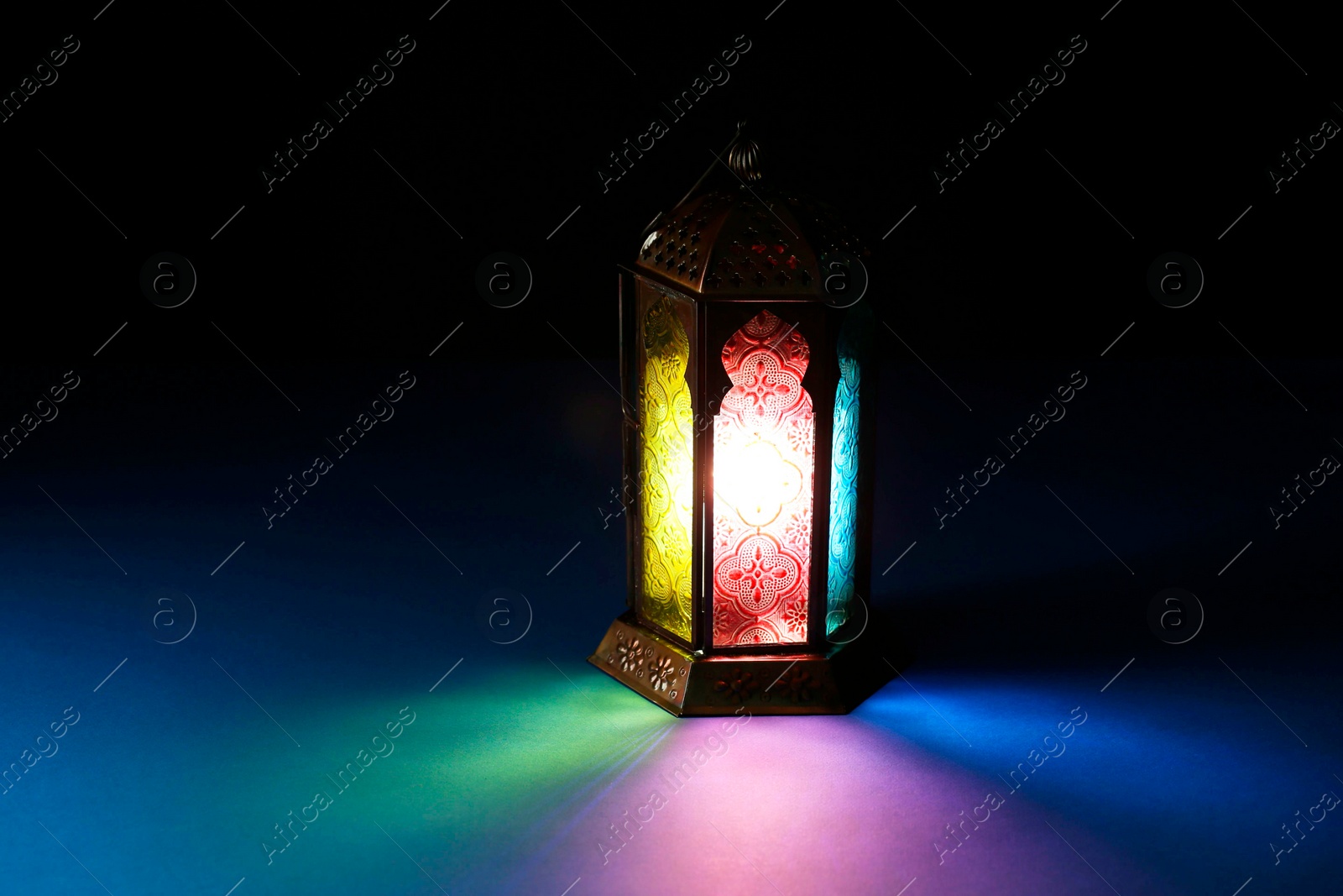 Photo of Decorative Arabic lantern on table against dark background. Space for text