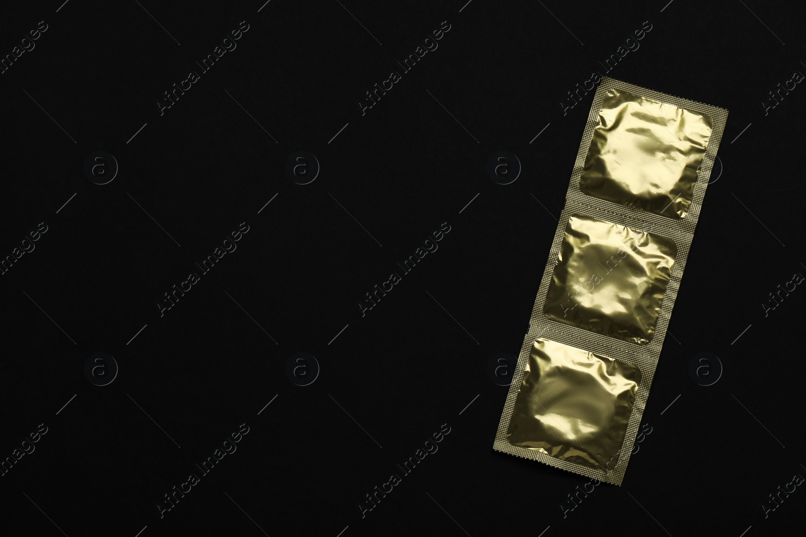 Photo of Condom packages on black background, top view and space for text. Safe sex