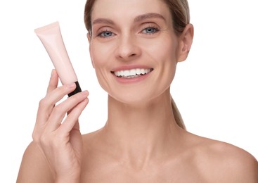 Woman holding tube with foundation on white background