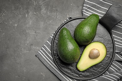 Photo of Delicious ripe avocados on grey table, top view. Space for text