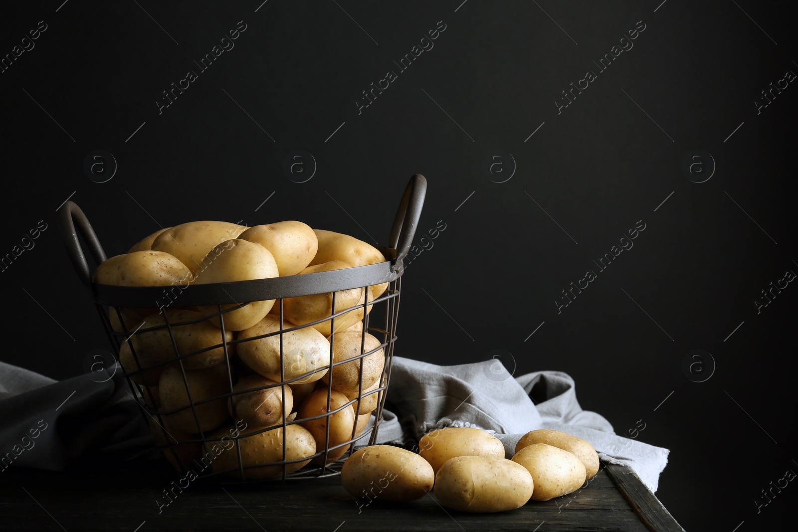 Photo of Composition with fresh organic potatoes and space for text on black background