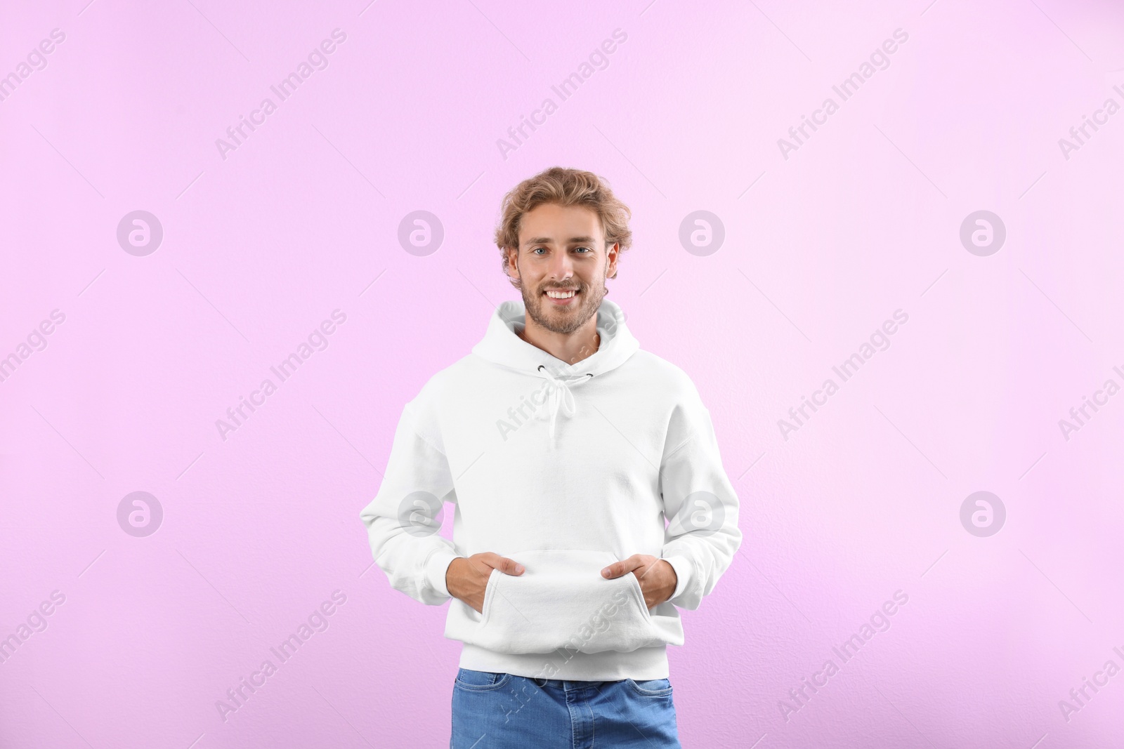 Photo of Portrait of man in hoodie sweater on color background. Space for design