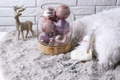 Composition with beautiful pink Christmas baubles on grey fur