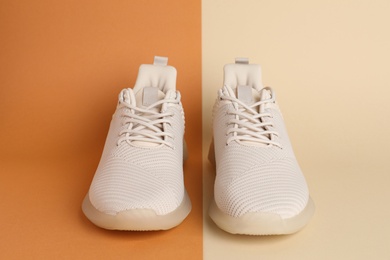 Photo of Pair of stylish sport shoes on color background