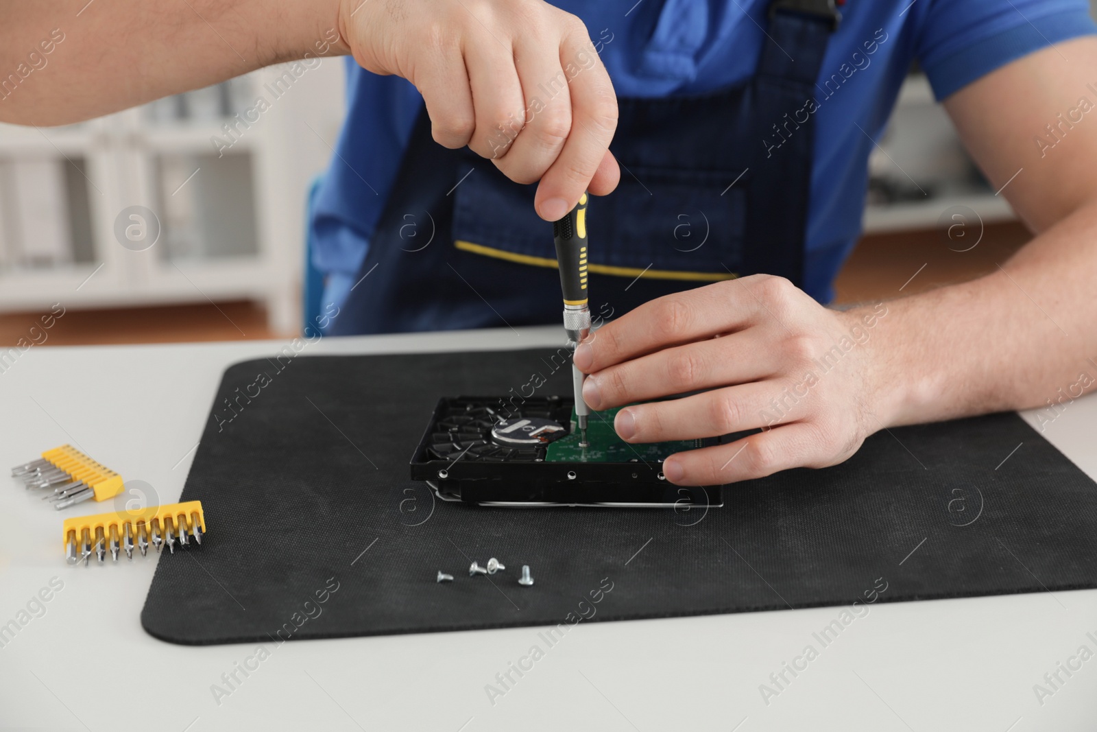 Photo of Male technician repairing hard drive at table, closeup