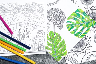 Photo of Antistress coloring pages and felt tip pens on grey table, flat lay