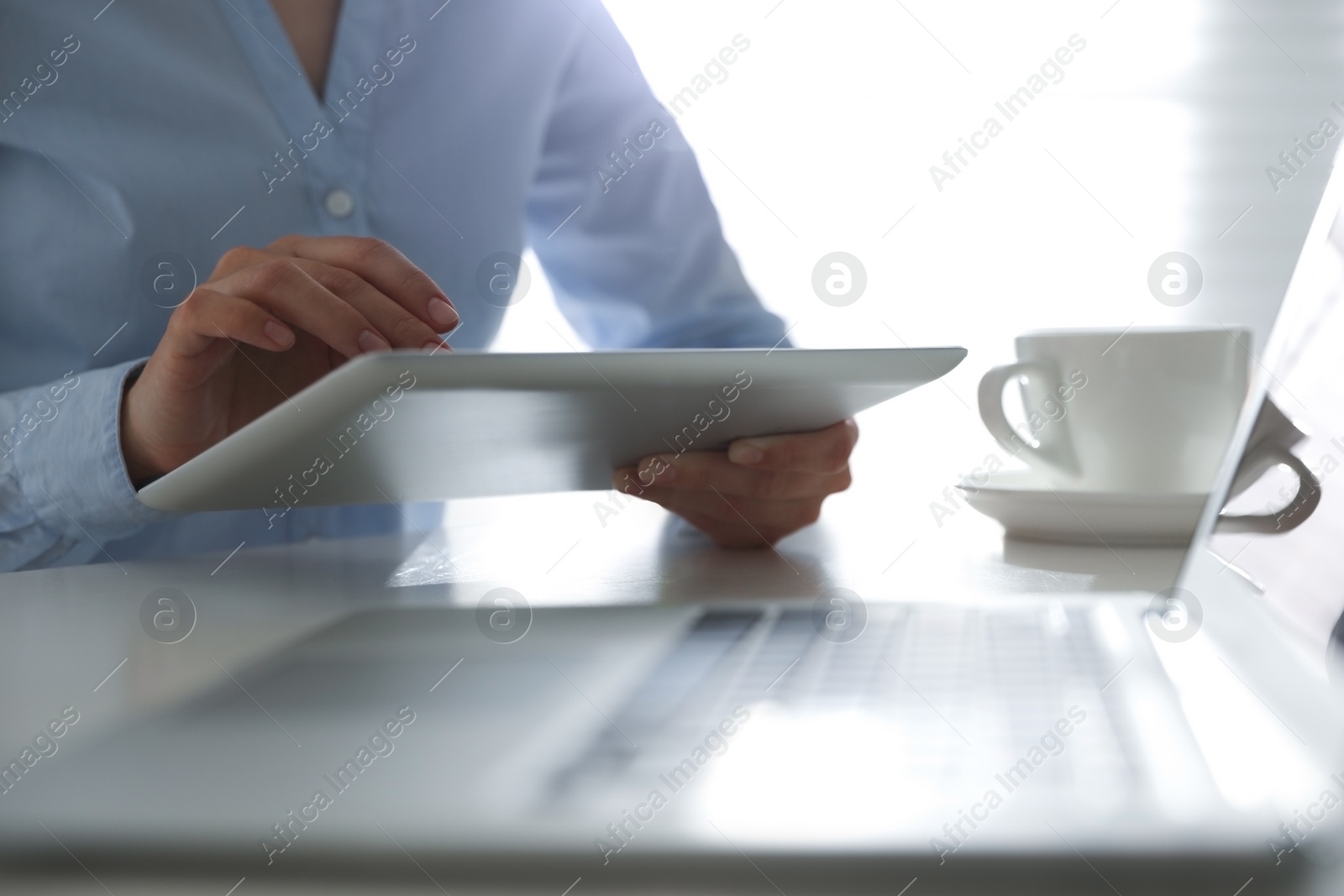 Photo of Businesswoman working with modern tablet at table in office, closeup