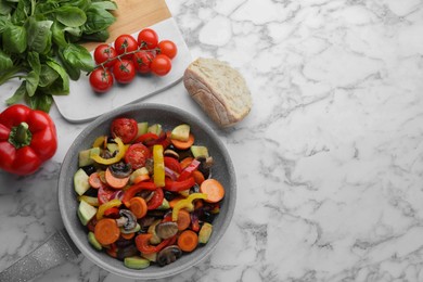 Photo of Mix of tasty vegetables in pan and ingredients on white marble table, flat lay. Space for text