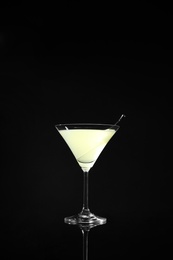 Glass of delicious cucumber martini on dark background