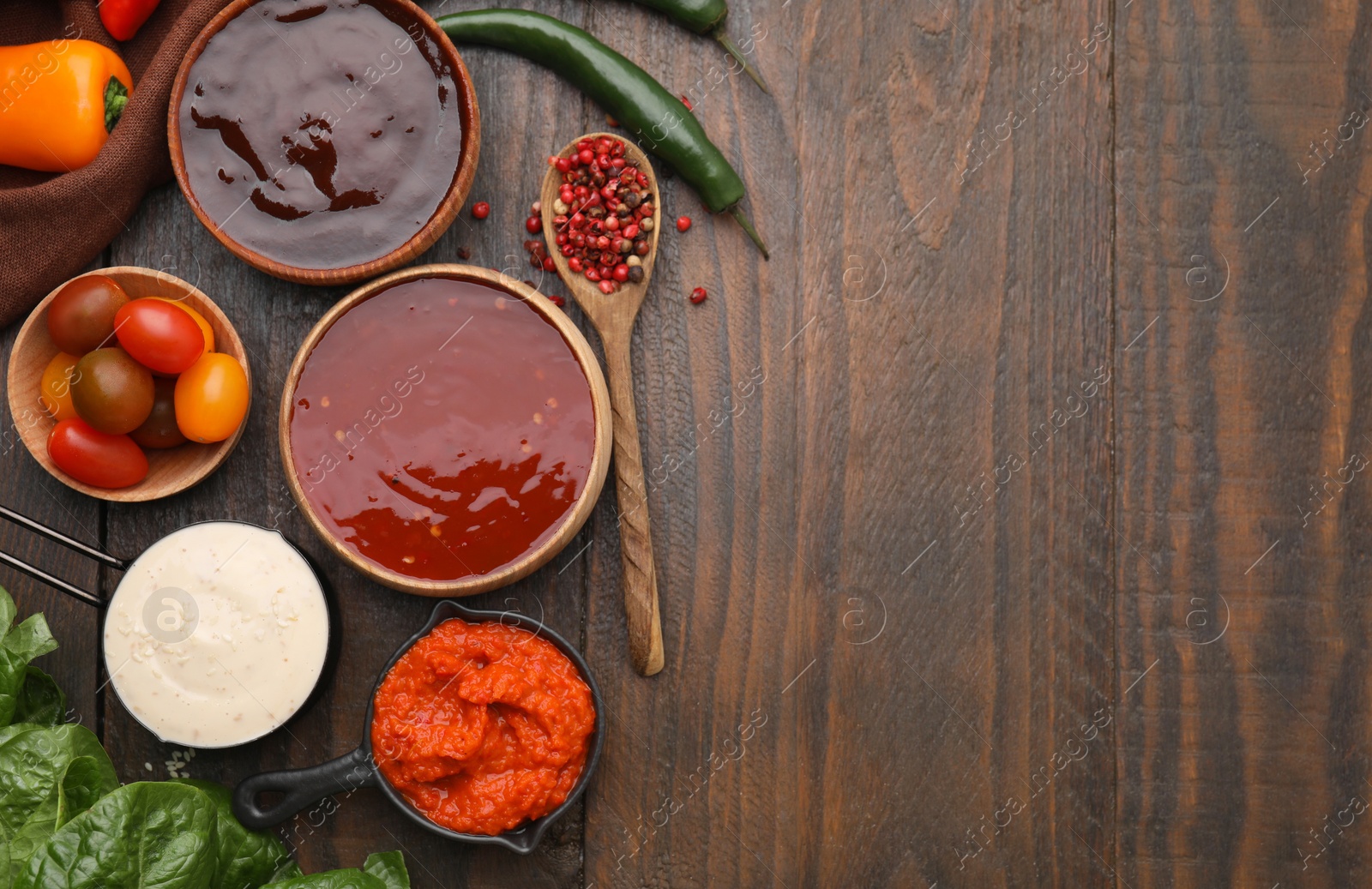 Photo of Different marinades and products on wooden table, flat lay. Space for text