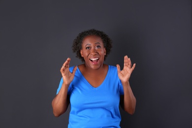 Portrait of happy African-American woman on black background