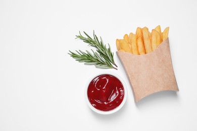 Paper cup with French fries, rosemary and ketchup on white table, flat lay. Space for text