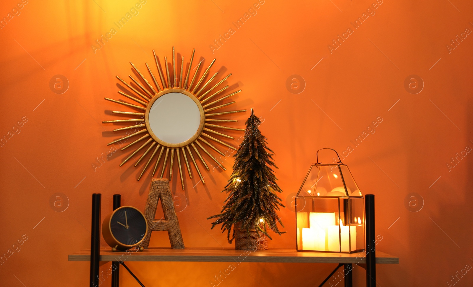 Photo of Shelf with Christmas decor near orange wall. Interior design