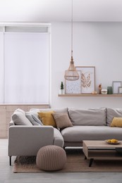 Photo of Stylish living room interior with comfortable grey sofa and coffee table