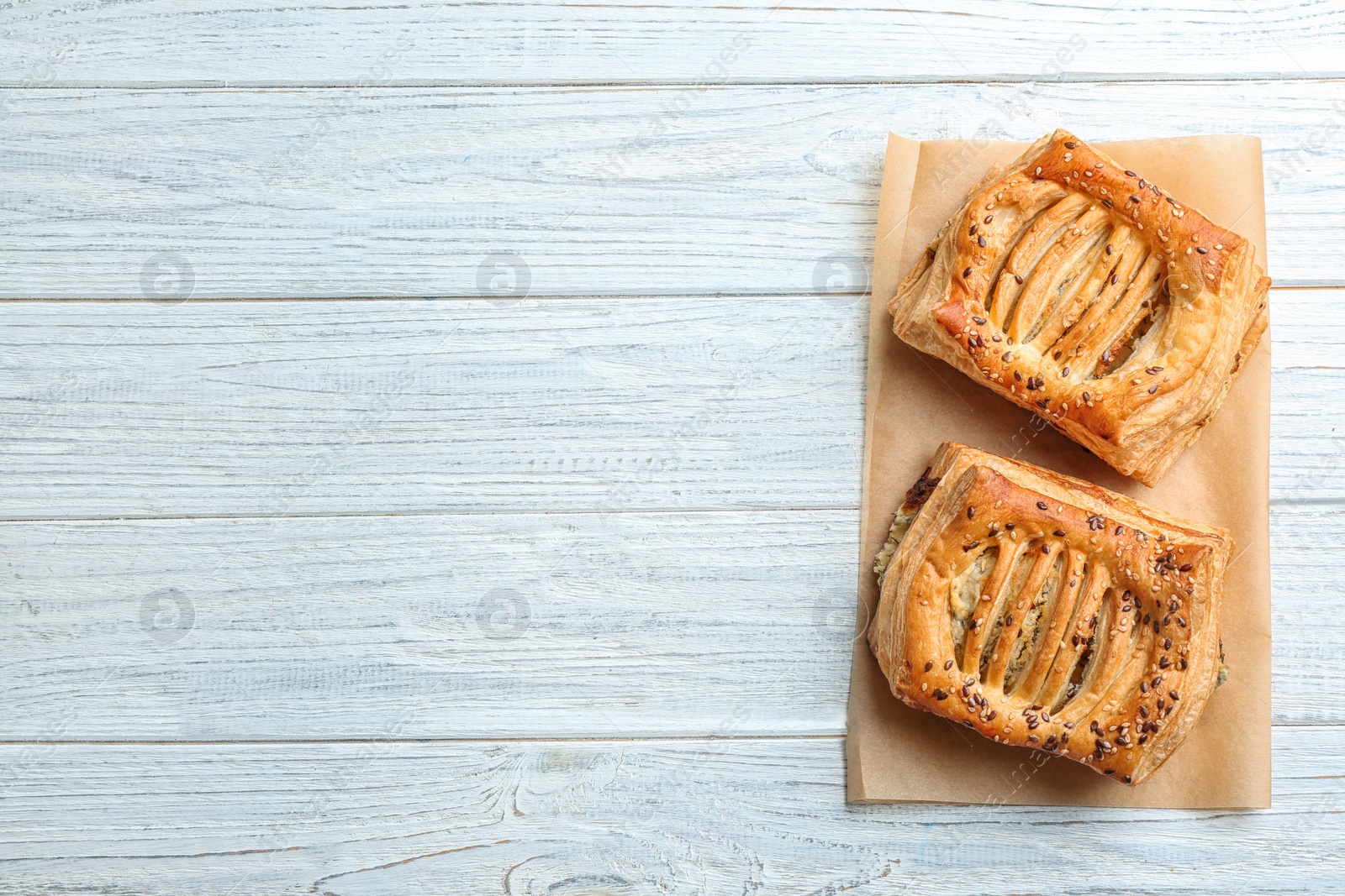 Photo of Fresh delicious puff pastry on white wooden table, top view. Space for text