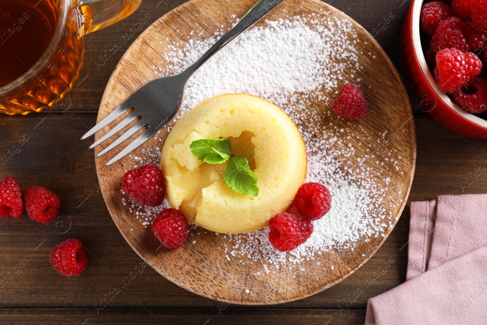 Photo of Tasty vanilla fondant with white chocolate and raspberries served on wooden table, flat lay