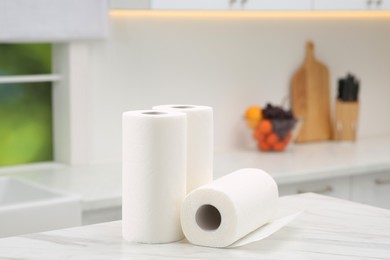 Photo of Rolls of paper towels on white marble table in kitchen