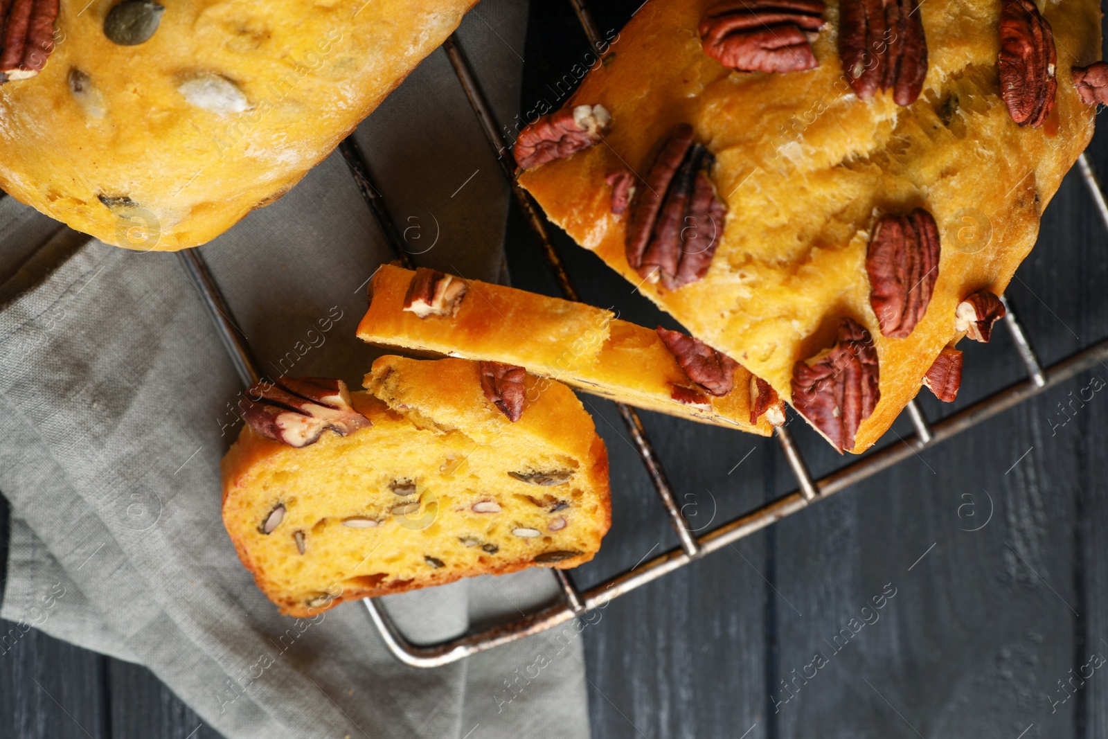 Photo of Delicious pumpkin bread with pecan nuts on black wooden table, flat lay