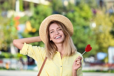 Beautiful smiling woman with candy on city street