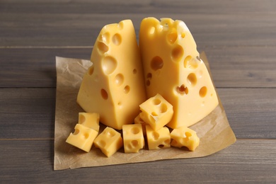 Photo of Pieces of delicious cheese on wooden table