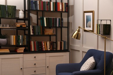 Photo of Cozy home library interior with collection of different books on shelves and comfortable place for reading