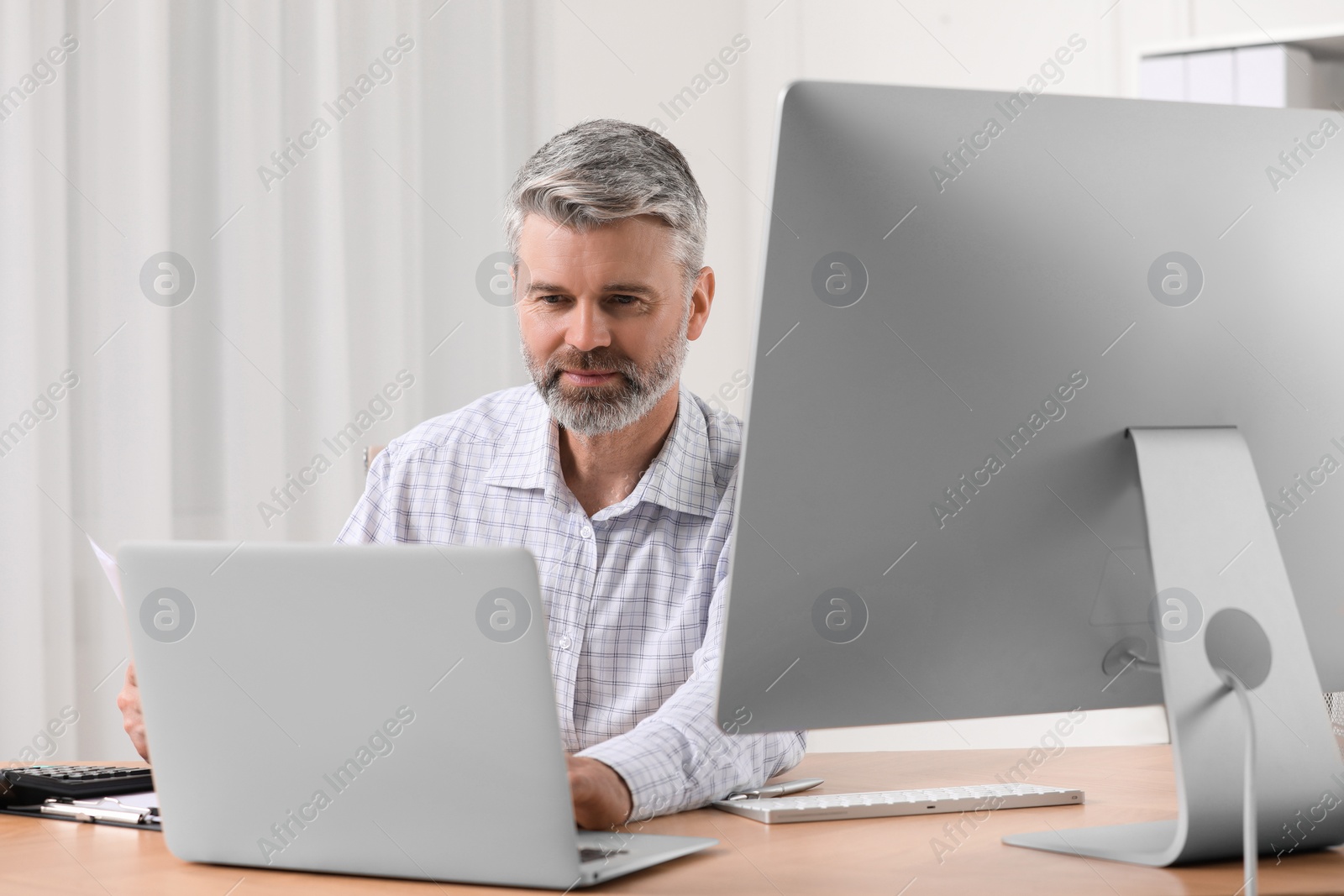 Photo of Professional accountant working at wooden desk in office