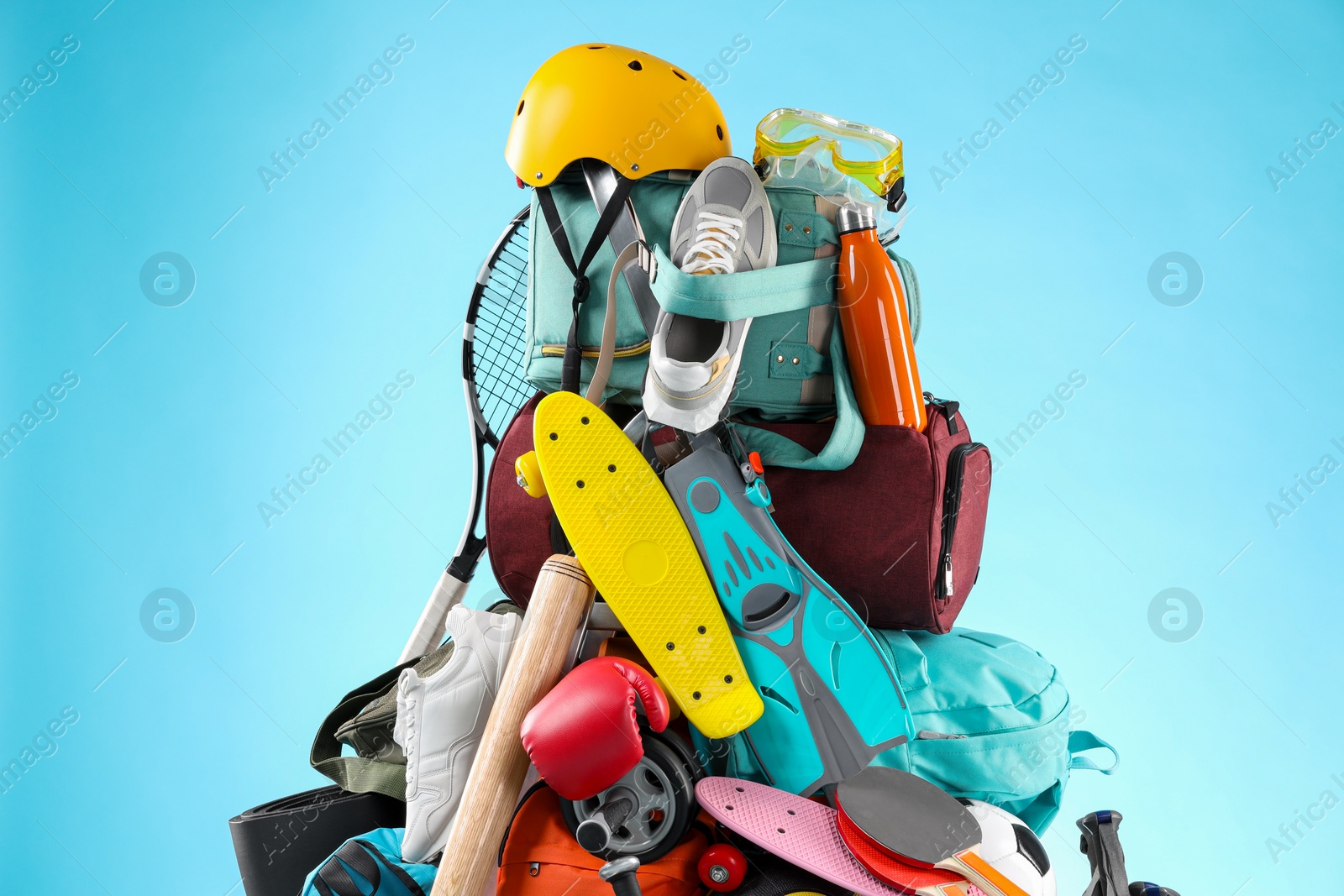 Photo of Many different sports equipment on light blue background