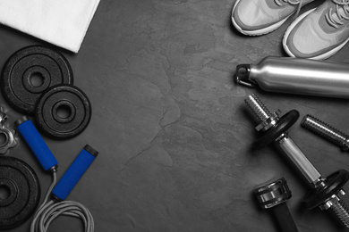 Photo of Gym equipment on black background, flat lay. Space for text