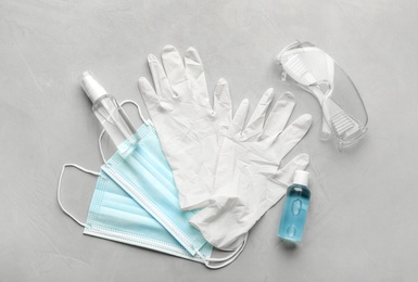 Photo of Flat lay composition with medical gloves, masks and hand sanitizers on grey background