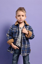 Photo of Fashion concept. Stylish boy posing on violet background