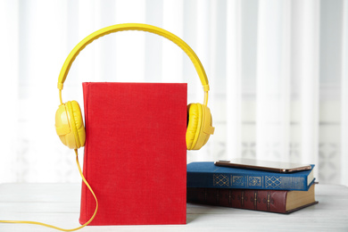Photo of Books, mobile phone and headphones on white wooden table