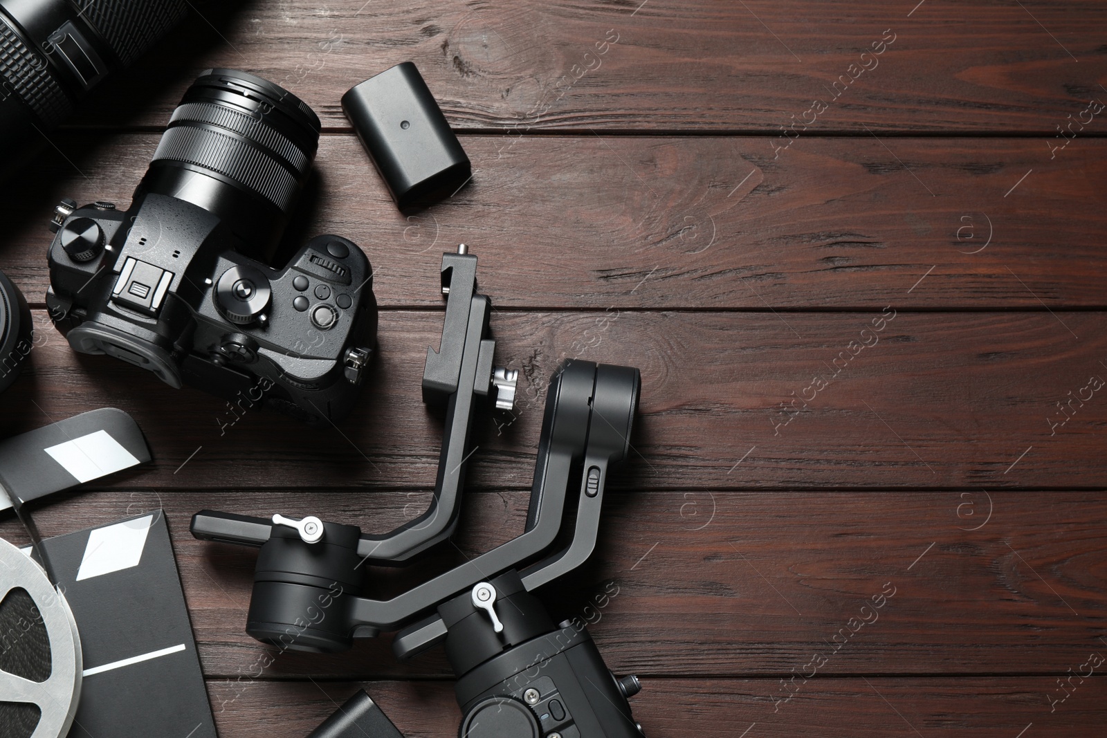 Photo of Flat lay composition with camera and video production equipment on brown wooden background. Space for text