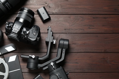 Photo of Flat lay composition with camera and video production equipment on brown wooden background. Space for text