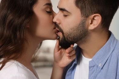 Photo of Love relationship. Passionate young couple kissing indoors, closeup