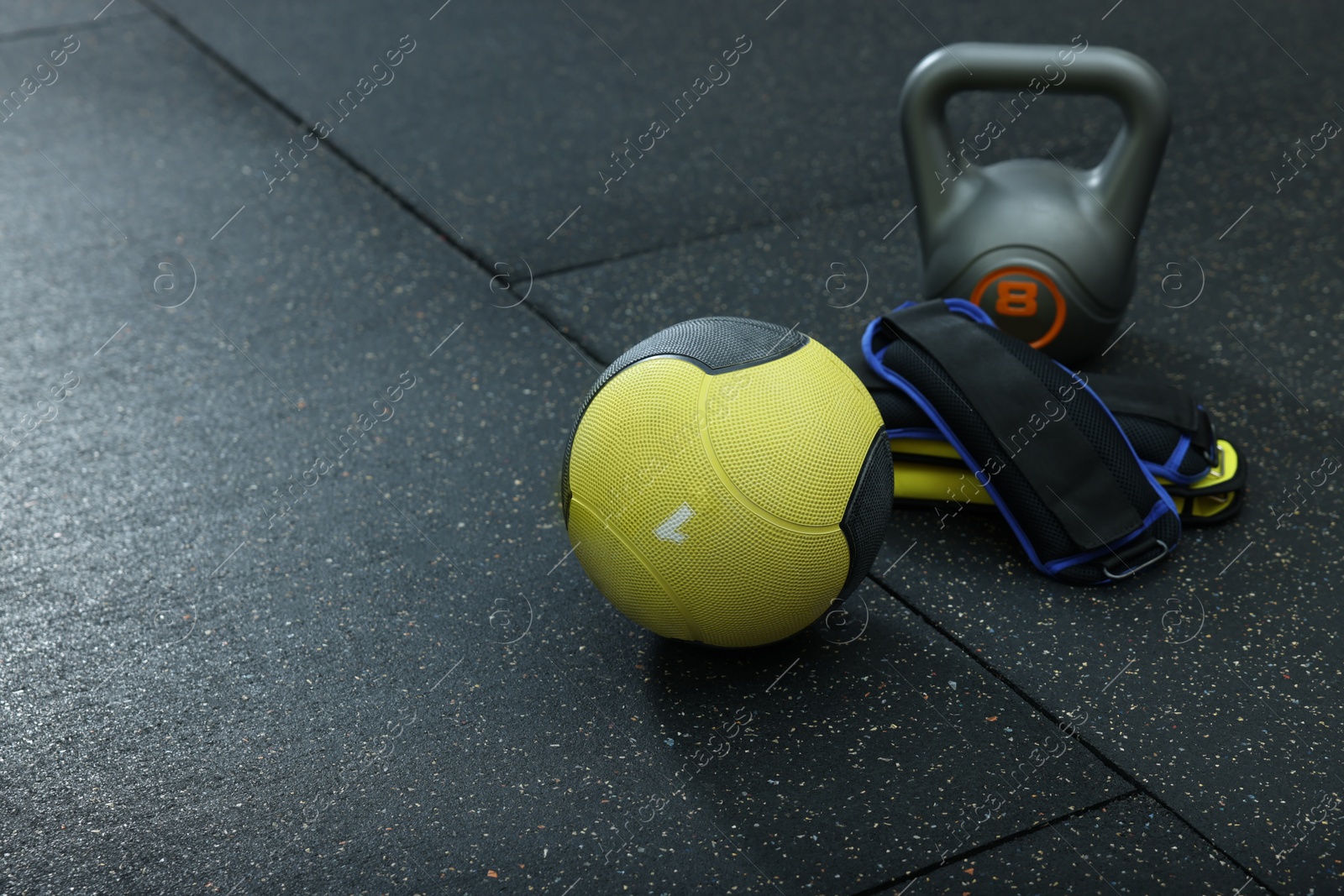 Photo of Yellow medicine ball, kettlebell and weighting agents on floor, space for text