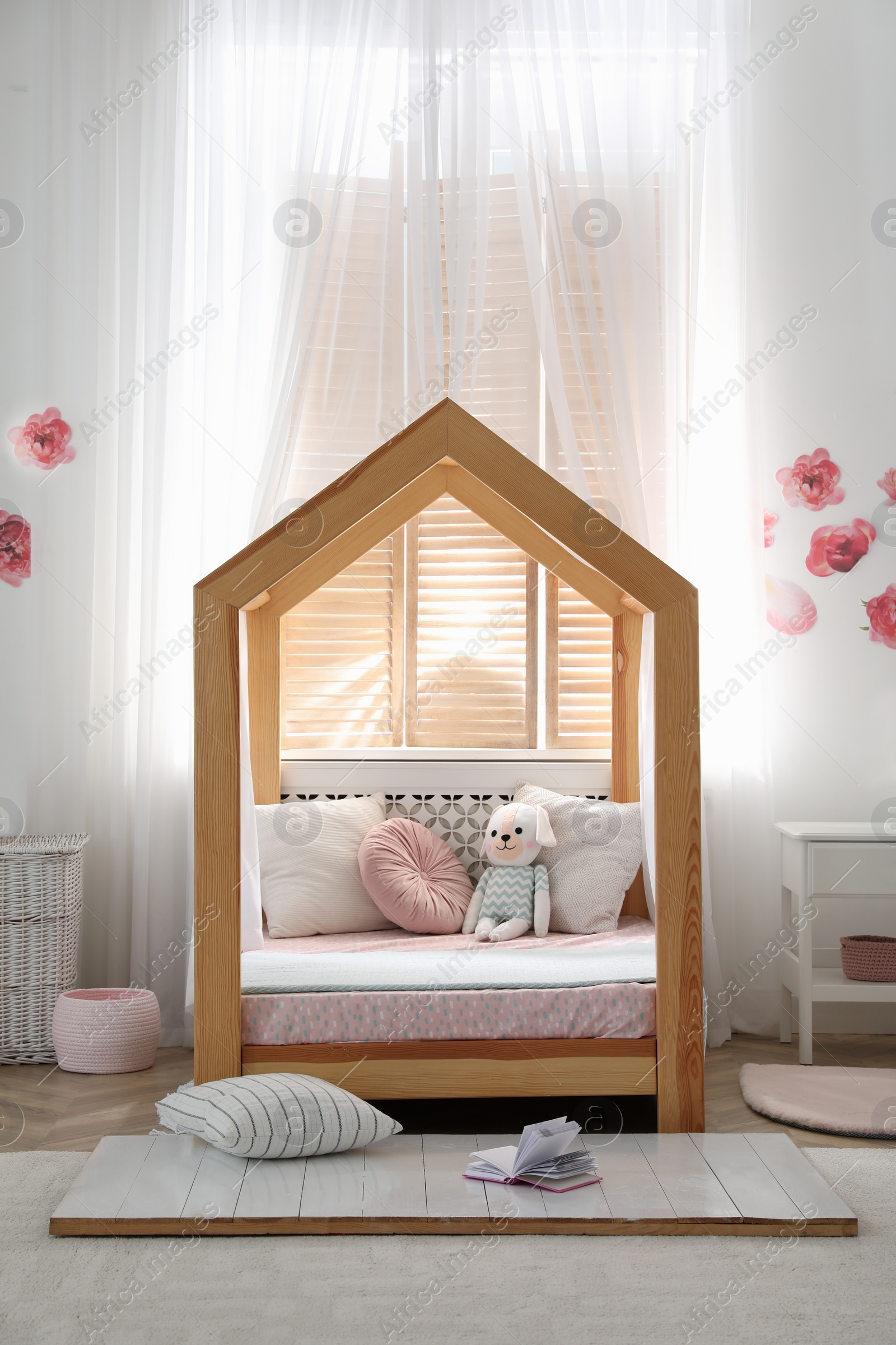 Photo of Stylish child room interior with wooden house bed