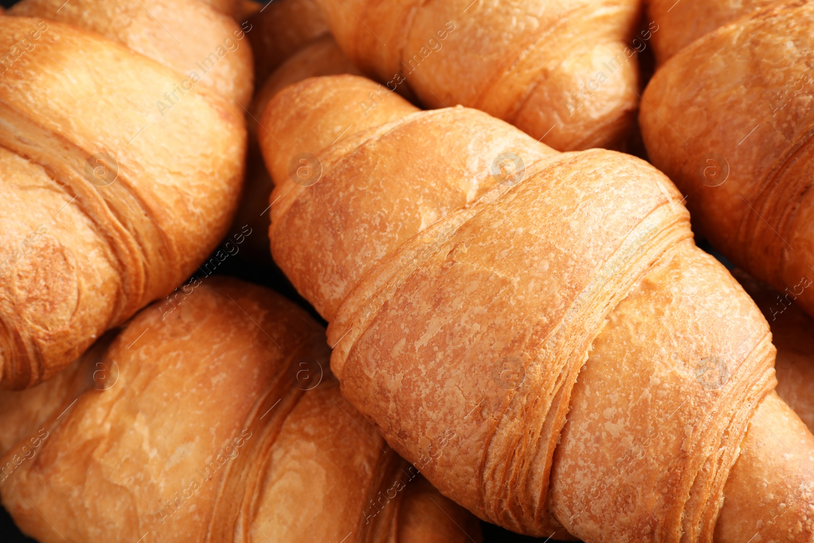 Photo of Tasty fresh croissants as background, closeup view
