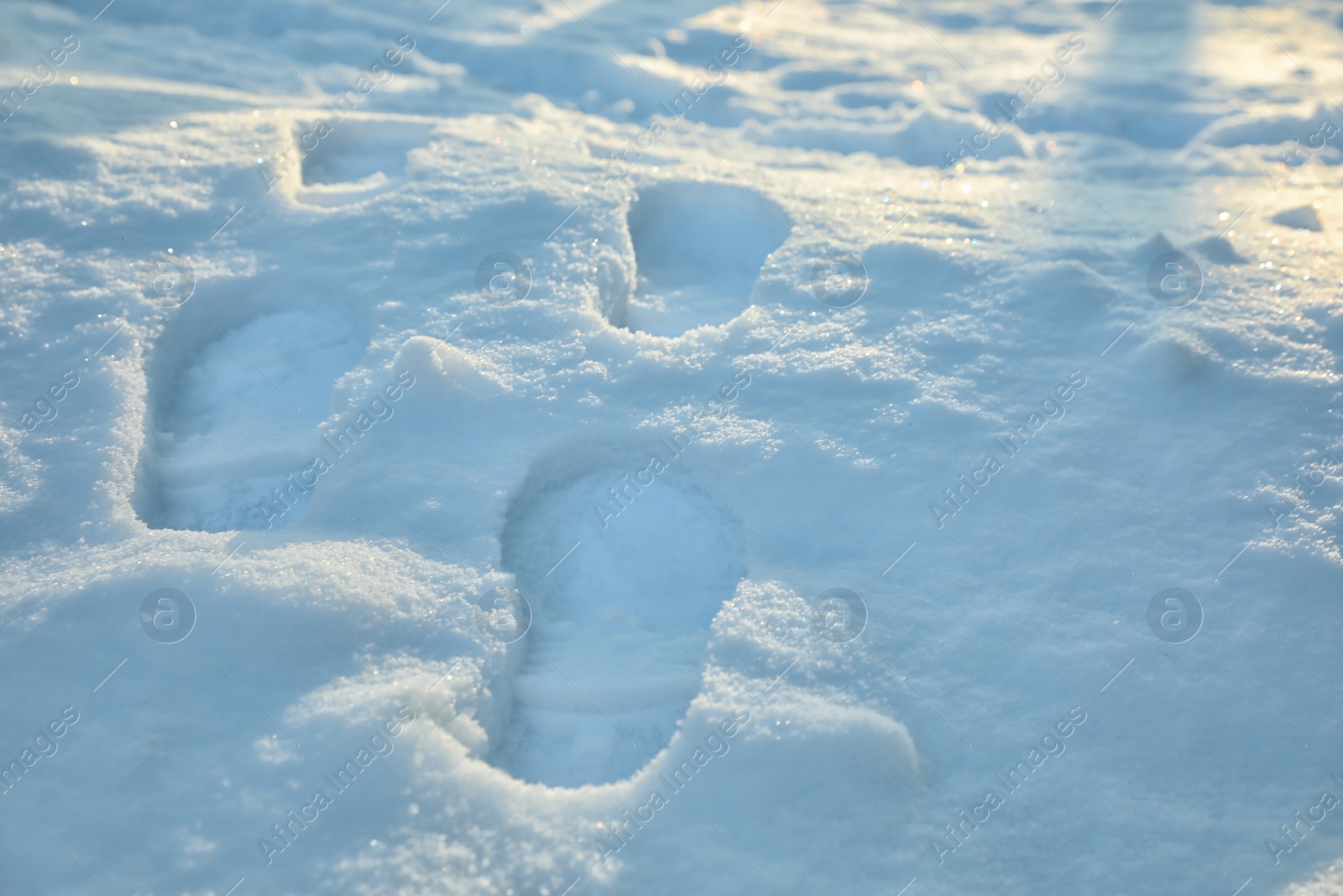 Photo of Footprints on white snow outdoors. Winter season