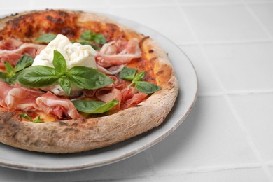 Photo of Delicious pizza with burrata cheese, basil and ham on white table, closeup. Space for text