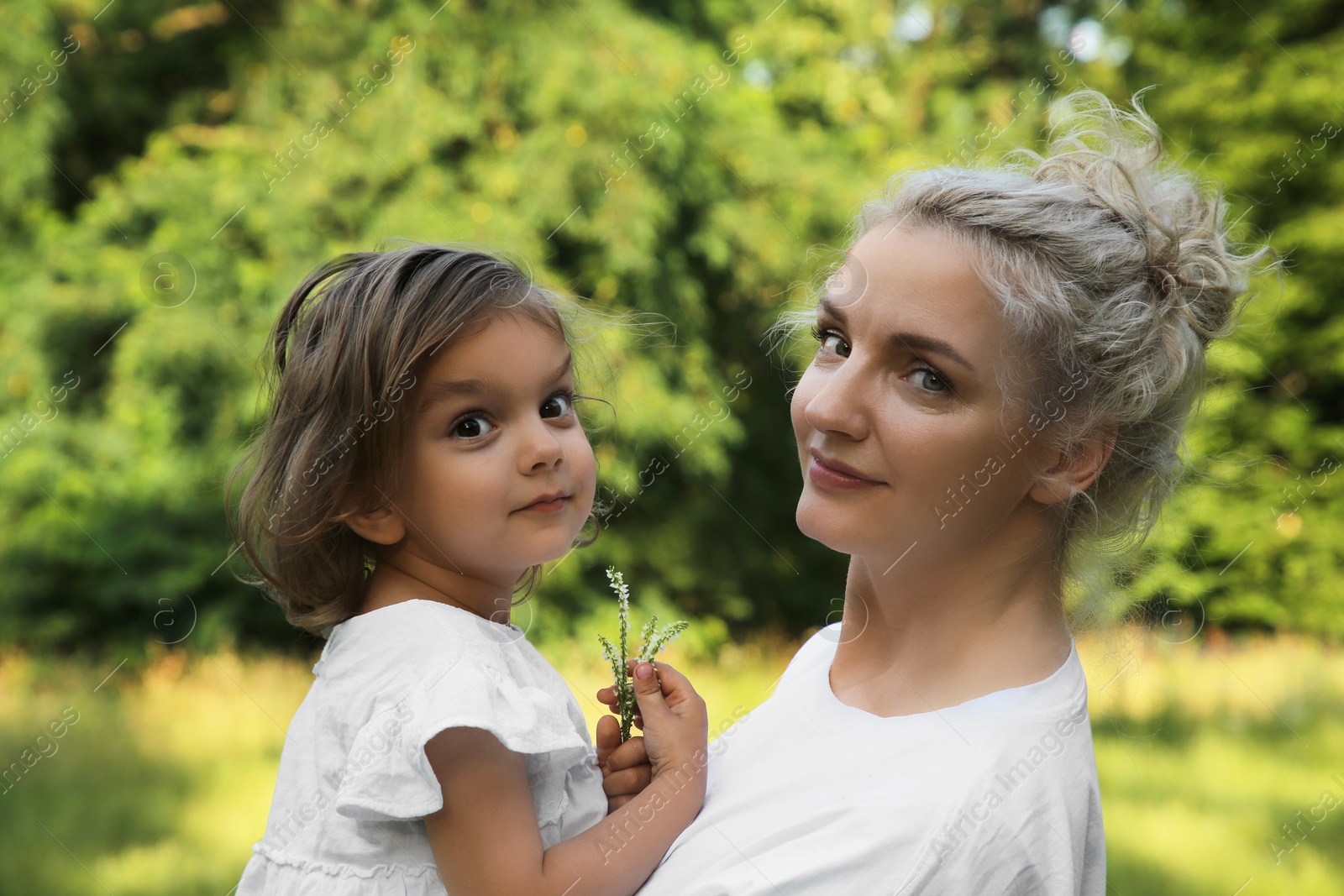 Photo of Beautiful mother with her cute daughter spending time together outdoors