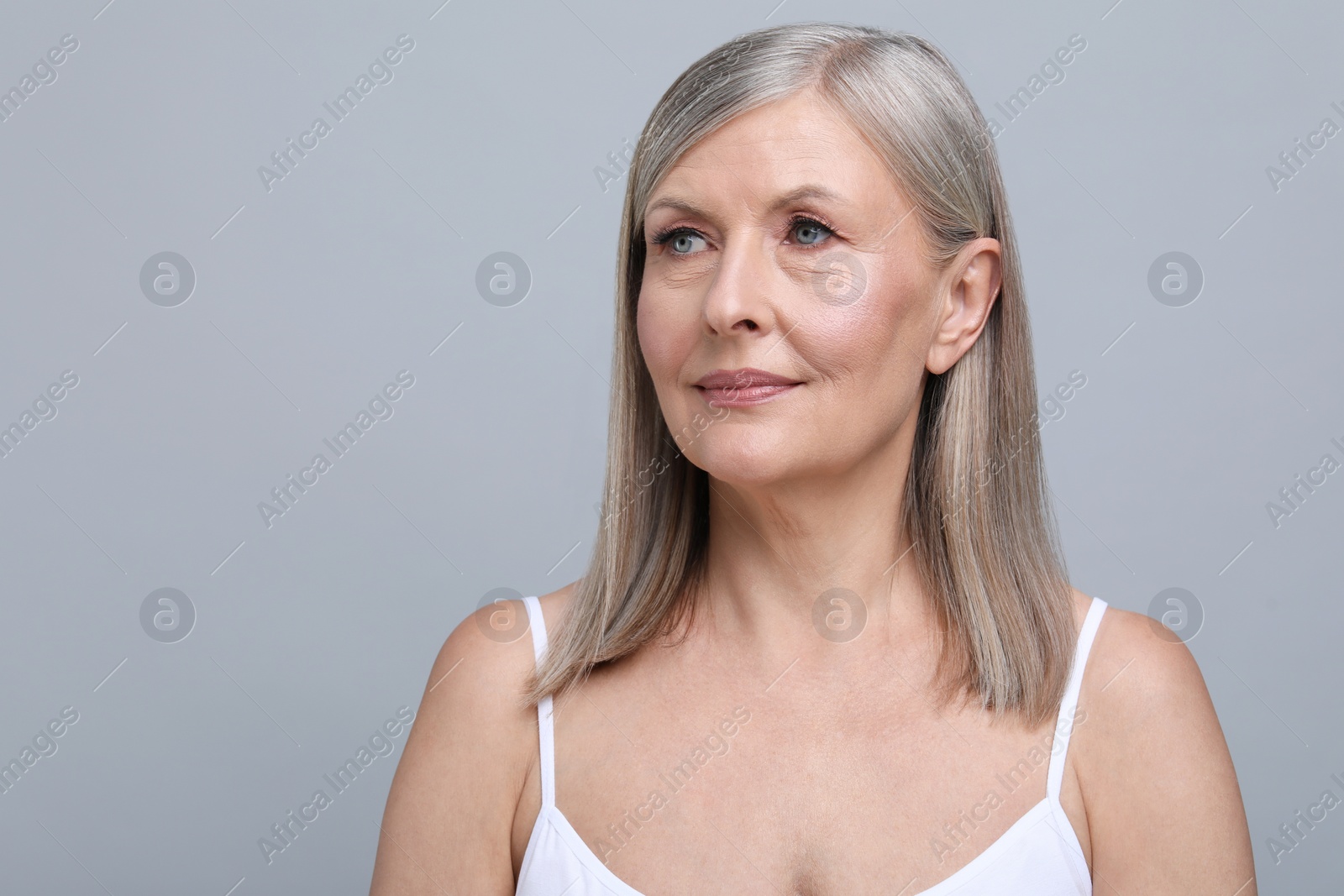 Photo of Portrait of beautiful senior woman on grey background. Space for text