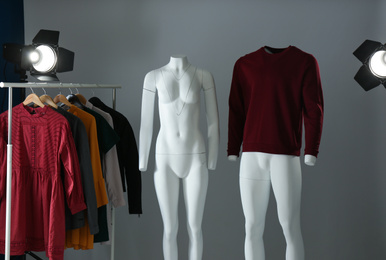 Ghost mannequins, clothes and professional lighting equipment in modern photo studio