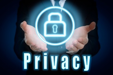 Image of Privacy policy. Man holding button with padlock against dark blue background, closeup