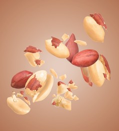 Many peanuts in air on brown background