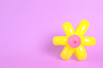 Photo of Flower figure made of modelling balloon on color background. Space for text