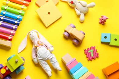 Flat lay composition with different toys on yellow background