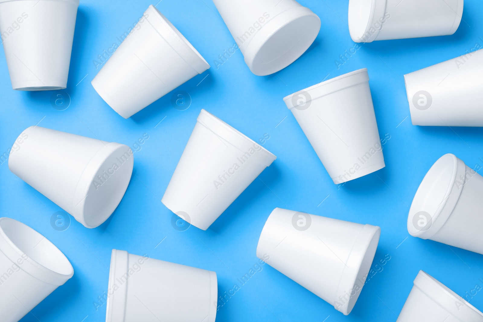 Photo of White styrofoam cups on light blue background, flat lay